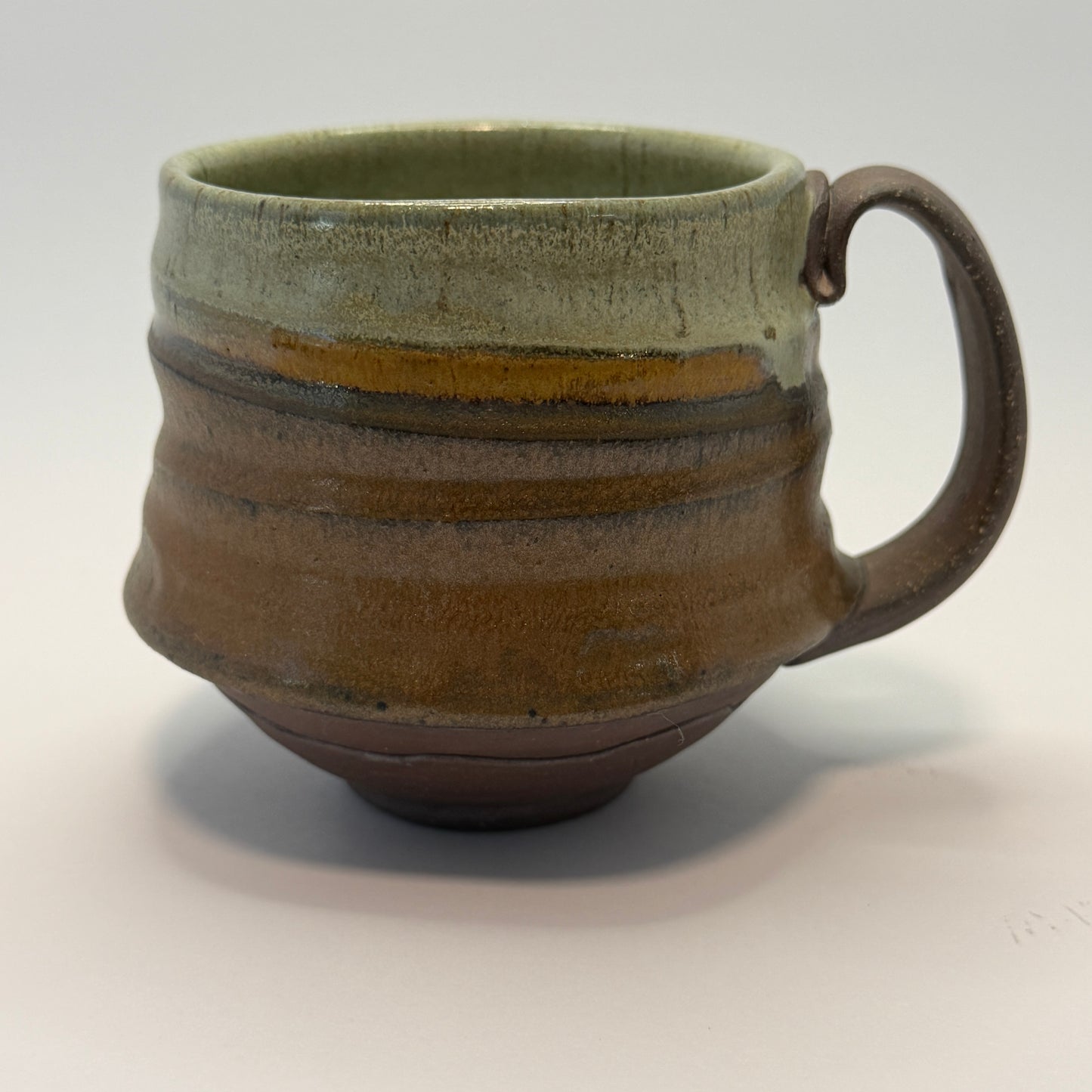 Ceramic mug with a handle on a light gray background