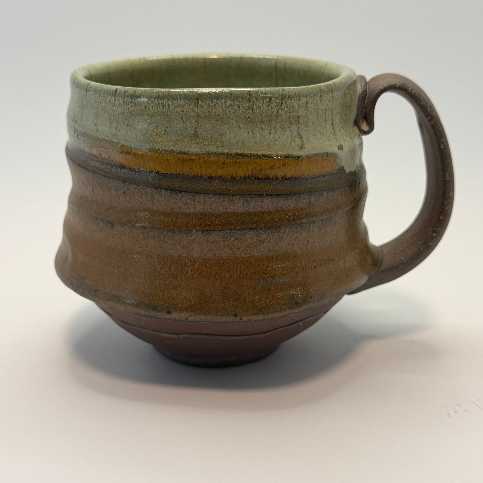 Ceramic mug with a handle on a light gray background